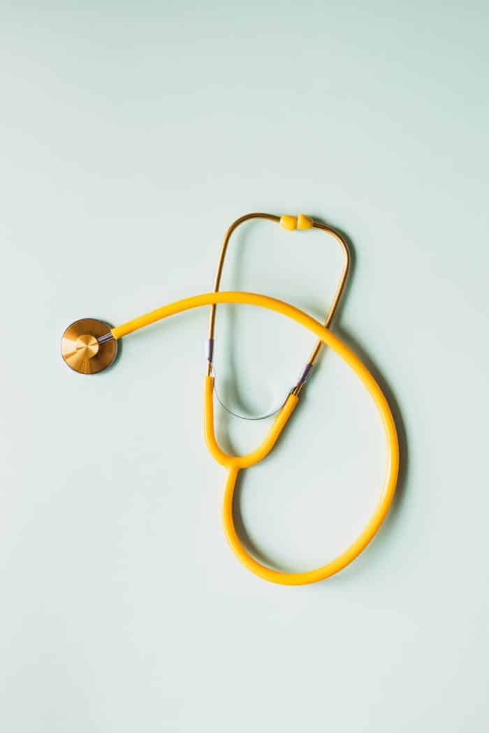 about-hero Top view of yellow medical stethoscope placed on white surface during coronavirus pandemic
